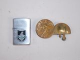 un briquet à côté d'un autre briquet sur lequel est apposée une médaille
