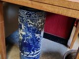 un vase bleu et blanc posé sous une table en bois