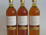 three bottles of wine sitting next to each other on a white surface