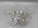 six verres d'eau posés sur une surface blanche