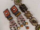 two pairs of bracelets with beads and stones on a white surface