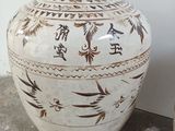 a large white vase sitting on the floor next to a pot