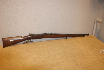 le fusil est posé sur la table près du mur