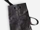 a black leather handbag with two compartments and a strap