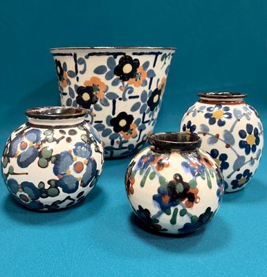 quatre vases posés sur une surface bleue