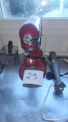 a red mixer sitting on a counter with a price tag on it