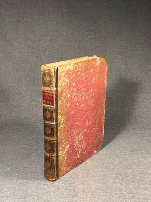 an old book sitting on top of a table next to a gray background