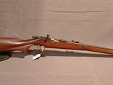 un vieux fusil avec un canon en bois et un étui en cuir