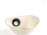 a white bowl with a black object in it