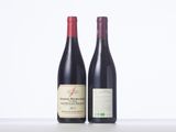 two bottles of red wine sitting next to each other on a table