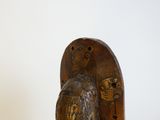 une sculpture en bois représentant un oiseau, posée sur un socle