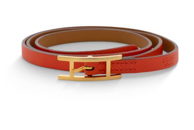 un gros plan d'une ceinture avec une boucle dorée sur fond blanc
