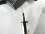 a fountain pen sitting on top of a piece of paper