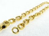 a close up of two gold chains on a white surface