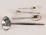 several spoons, forks, and spoon rest on a white surface