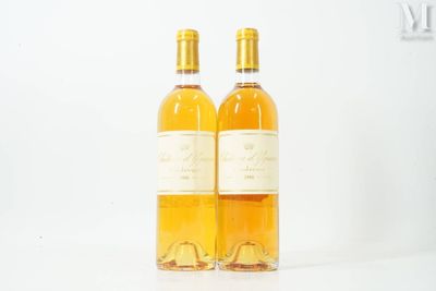 deux bouteilles de vin posées l'une à côté de l'autre sur une surface blanche