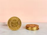 two gold coins sitting on top of a marble counter top