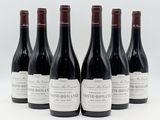 six bottles of wine are lined up in a row on a white surface