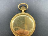 an image of a gold pocket watch on a black surface