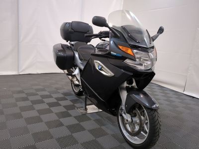 une moto noire garée sur un sol à damier