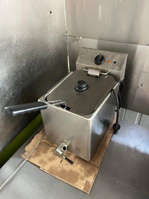 une petite friteuse électrique en inox à un bac METRO, un mi…