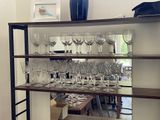 a shelf with wine glasses on it in a room