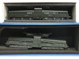 deux trains miniatures posés dans une boîte sur une surface blanche