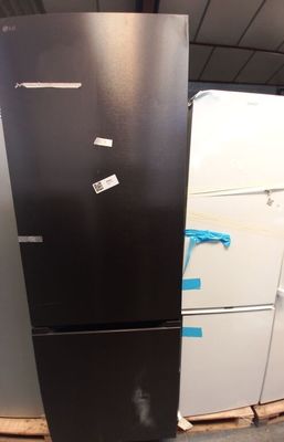 un réfrigérateur noir au milieu d'une pile de réfrigérateurs blancs
