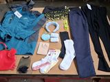 une table sur laquelle sont posés de nombreux vêtements et chaussures