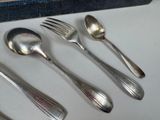 five silver spoons and two silver spoons on a table