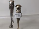 two silver spoons that are on display in a glass case
