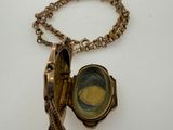 a gold locke with a tassel attached to it
