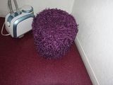 a purple ball sitting on the floor next to a white wall
