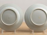 two white plates with gold rims on a table