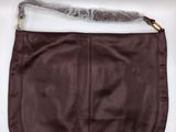 a close up of a brown leather purse on a white surface
