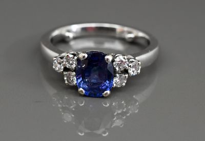 un gros plan d'une bague en saphir bleu et diamants posée sur une table