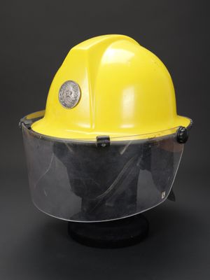 un gros plan d'un casque de chantier jaune muni d'une visière transparente
