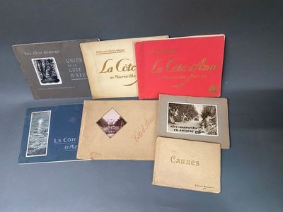 Plusieurs livres sont alignés sur une table devant un fond noir.