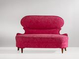 une chaise rose avec des pieds en bois et une assise rembourrée rose
