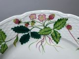a white plate with pink flowers and green leaves on it