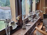 une longue table sur laquelle sont posées de nombreuses lampes, près d'une fenêtre