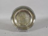 a silver plate on a clear stand on a white surface