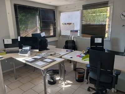 une image représentant un bureau avec de nombreux bureaux et ordinateurs