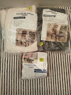 deux sacs de nourriture pour chat posés sur un lit, avec un chat assis dessus