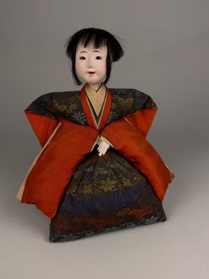 une poupée ancienne représentant une femme vêtue d'un kimono