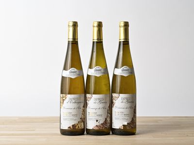 trois bouteilles de vin posées sur une table en bois