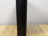 two black metal bookends on a wooden table with a clock in the background