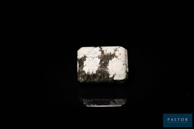 a close up of a white stone on a black surface