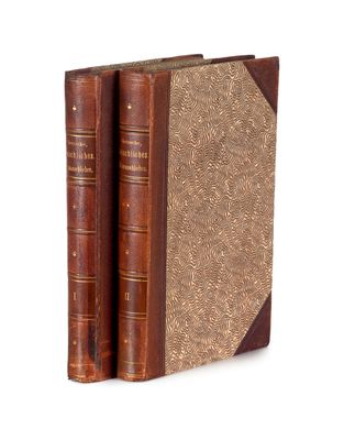 une vieille paire de livres posés l'un à côté de l'autre sur une surface blanche