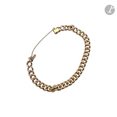 gros plan d'un bracelet en chaîne en or sur fond blanc